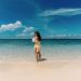 woman enjoying a tropical beach with clear skies