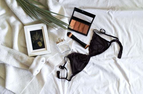 black brassiere and makeup on bed