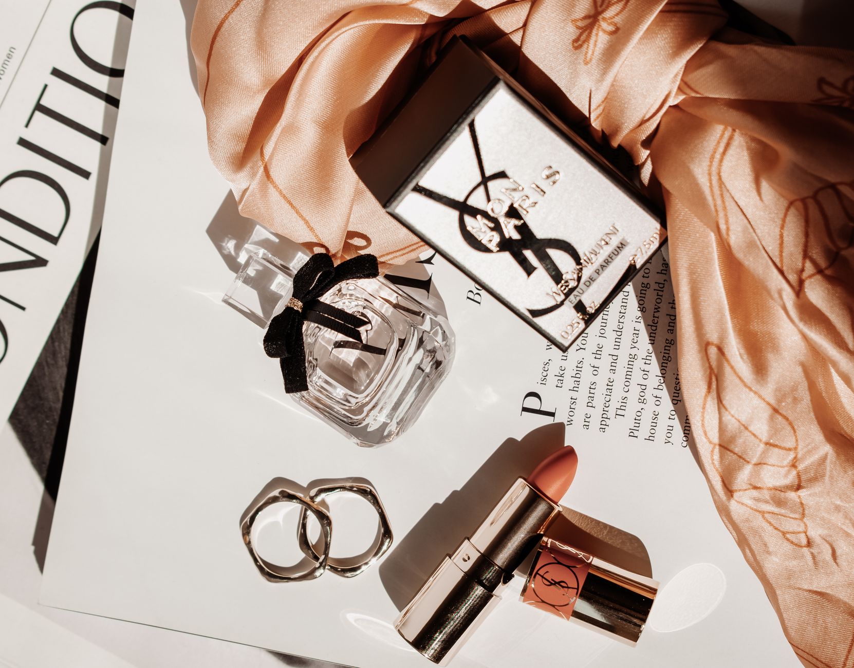 perfume bottle and lipstick on a magazine